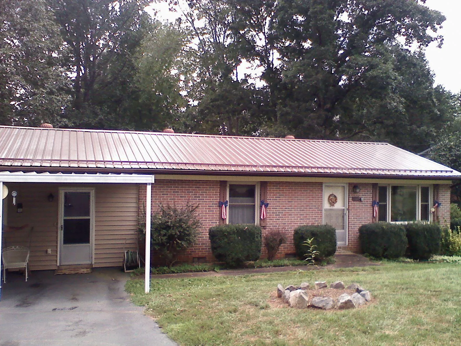 Bronze metal roof and carport on a brick ranch home — Roof Repair work by our crew in Merrick