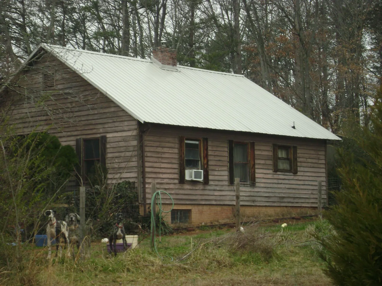 White metal roof on an old wood sided farmhouse, from a Metal Roof Installation job in Merrick